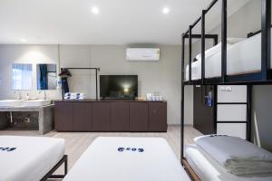 a room with two bunk beds and a television at Kokotel Phuket Patong - SHA Extra Plus in Patong Beach