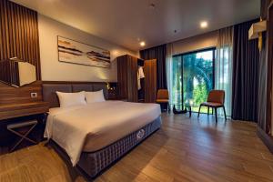 a bedroom with a large bed and a large window at ZEN RIVERSIDE HOTEL & RESIDENCES in Hai Phong