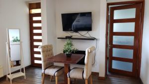 uma sala de jantar com uma mesa e uma televisão na parede em Borde Luz Hotel Boutique em Pucón