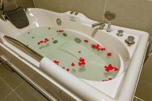 a white bath tub with red flowers in it at ZEN RIVERSIDE HOTEL & RESIDENCES in Hai Phong +64 photos