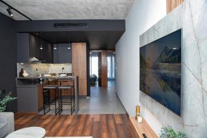 a kitchen and living room with a large painting on the wall at Appartement neuf 2 chambres avec salle de sport in Casablanca