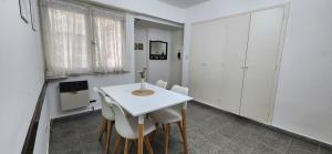 Depto de 2 ambientes zona Guemes (2) في مار ديل بلاتا: غرفة طعام بيضاء مع طاولة بيضاء وكراسي