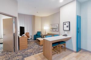 a hotel room with a desk and a living room at Candlewood Suites Oklahoma City-Moore, an IHG Hotel in Moore