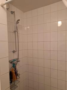a shower in a bathroom with white tiles at Sky Home Room 1 in Amsterdam