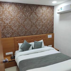 een slaapkamer met een groot bed met een bruine muur bij HOTEL GLOBLE in Vadodara