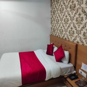 een slaapkamer met een bed met rode kussens bij HOTEL GLOBLE in Vadodara