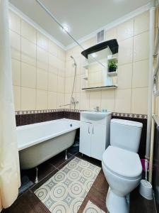 a bathroom with a toilet and a tub and a sink at Infinity Estate MEGA Park in Almaty