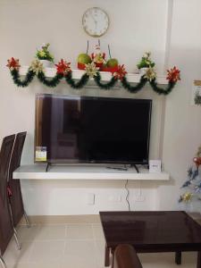 Una televisione con corone di Natale e un orologio su un muro di Fall in love with our Condo Unit SMDC Cheer Residences a Marilao