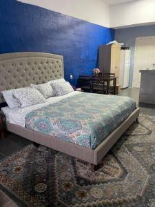 1 dormitorio con 1 cama grande y pared azul en Sale’aula Lava Studio Apartment en Saleaula
