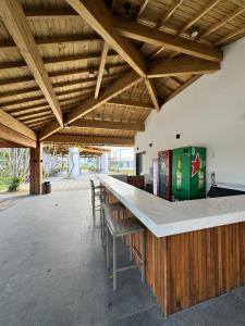 eine Bar in einem Gebäude mit Holzdecken und Stühlen in der Unterkunft Apartamento studio novo e completo em Praia do Forte! 900m da Vila! in Praia do Forte