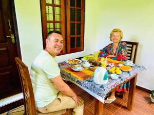 un hombre y una mujer sentados en una mesa en Priyavimana resort en Habarana