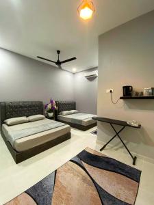 um quarto com 2 camas e uma ventoinha de tecto em Roomstay Kak Ton em Kuala Terengganu