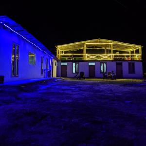 a building lit up at night with blue lights at Damnbro Cafe & Stay KASOL in Kasol