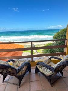 2 sillas en un balcón con vistas al océano en Casa Florianópolis, en Florianópolis