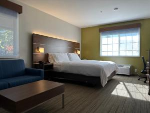 um quarto de hotel com uma cama e uma cadeira azul em Holiday Inn Express & Suites Mountain View, an IHG Hotel em Mountain View
