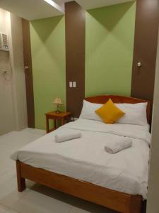 a bedroom with a bed with two pillows on it at Maison De Gloria in Daraga