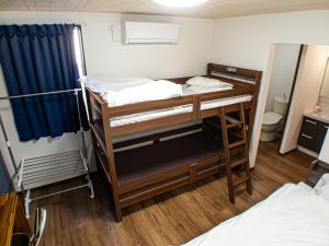 a room with two bunk beds and a bathroom at Shima no Hotel in Sado