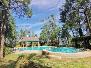 a swimming pool in a yard with a house at Crosswinds Tagaytay Three Bedroom Suite in Tagaytay