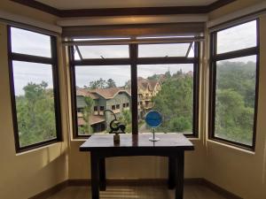 a table in front of a window with a view at Crosswinds Tagaytay Three Bedroom Suite in Tagaytay