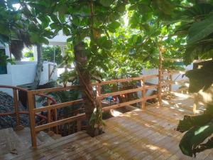 a wooden deck with a tree in the middle at Bambú Ecocabañas in San Agustinillo