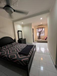 um quarto com uma cama e um sofá num quarto em HANI MAWADDAH HOMESTAY SEKSYEN 7 SHAH ALAM em Shah Alam