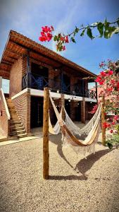 a house with a hammock in front of it at Suítes Bosque de Flecheiras in Flecheiras