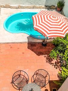 einen Pool mit Sonnenschirm, Tisch und Stühlen in der Unterkunft Casa Candiotti in Paraná