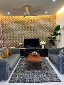 uma sala de estar com dois sofás e uma mesa de centro em HANI MAWADDAH HOMESTAY SEKSYEN 7 SHAH ALAM em Shah Alam