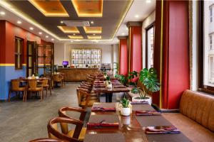 una fila di tavoli in un ristorante con pareti rosse di Atisha Hotel a Kathmandu