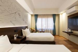 Letto o letti in una camera di Atisha Hotel