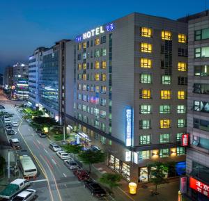 un bâtiment d'hôtel avec des voitures garées dans une rue de la ville dans l'établissement Incheon The Hotel Yeongjong, à Incheon