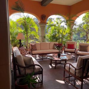 クエルナバカにあるVilla Colonial los Sabinosのヤシの木が植わるパティオ(椅子、テーブル付) +9枚の写真