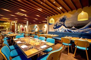 um restaurante com mesas e cadeiras e um grande mural em Lovely Room Oceanami Resort em Long Hai