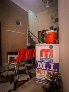 a room with two red chairs and a box at m.i. guest house in Bikaner