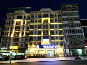 een groot gebouw met 's nachts lichten ervoor bij Sok Eng Hotel ( សណ្ឋាគារ សុខ អេង ) in Sihanoukville