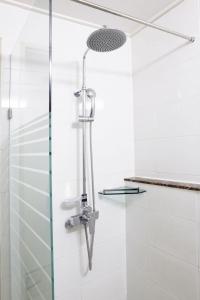 La salle de bains est pourvue d'une douche et de carrelage blanc. dans l'établissement Incheon The Hotel Yeongjong, à Incheon