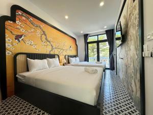 sypialnia z 2 łóżkami i obrazem na ścianie w obiekcie Mộc Lâm Homestay w Duong Dong