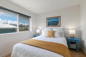 Un dormitorio blanco con una cama y una ventana. en Lookout 100m to the Ocean and Pet-Friendly, en Ocean Grove