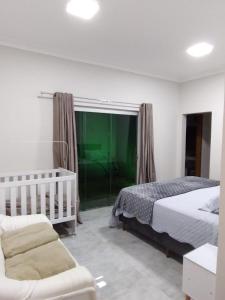 1 dormitorio con cama y ventana grande en Casa de aluguel temporada, en Lagoa Santa