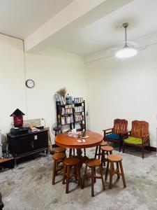 a room with a table and chairs and a book shelf at N-square Homestay in Yuanli