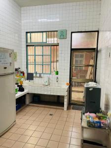 a kitchen with a sink and a refrigerator at N-square Homestay in Yuanli