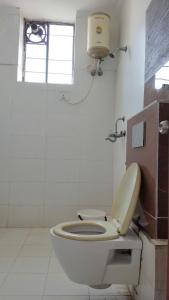 łazienka z białą toaletą i oknem w obiekcie Jhalana Resort & pool party w mieście Dżajpur