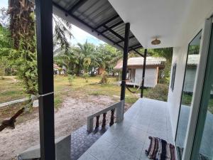 Elle offre une vue sur l'extérieur d'une maison dotée d'une terrasse couverte. dans l'établissement Vijit Bungalow, à Ko Phayam