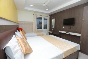 a bedroom with a large bed and a television at HOTEL PALACE in Madurai