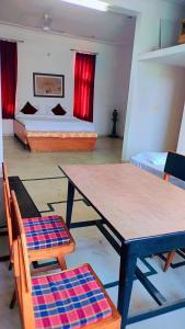 um quarto com uma mesa e cadeiras e uma cama em Jhalana Resort & pool party em Jaipur