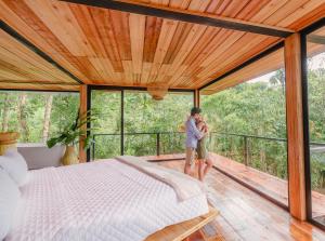 Cedro Amazon Lodge في Mera: امرأة تقف في غرفة نوم مع سرير على سطح السفينة