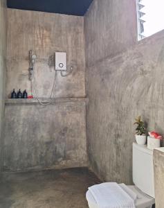a shower in a bathroom with a concrete wall at Bamboo Surf Beach in San Isidro