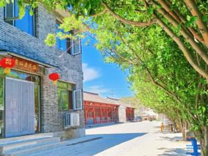 MiyunにあるGubeikou Great Wall Juxian Residents' Lodgingの赤窓付きの建物の通り景色