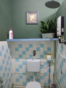 a bathroom with a toilet with blue and white tiles at Marco Polo Guest House in Kuching