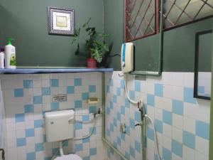 a bathroom with a toilet with blue and white tiles at Marco Polo Guest House in Kuching